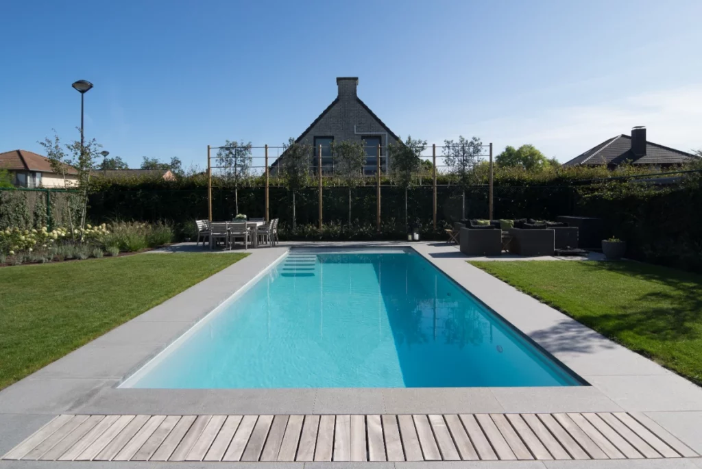 Ein professionell gebauter Pool in einem Garten mit Sitzgelegenheiten.